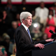 Michigan Governor Rick Snyder stands and listens to the boos of the crowd when he takes to the stage to speak before U.S. President Barack Obama speaks at Northwest High School about the Flint water contamination crises